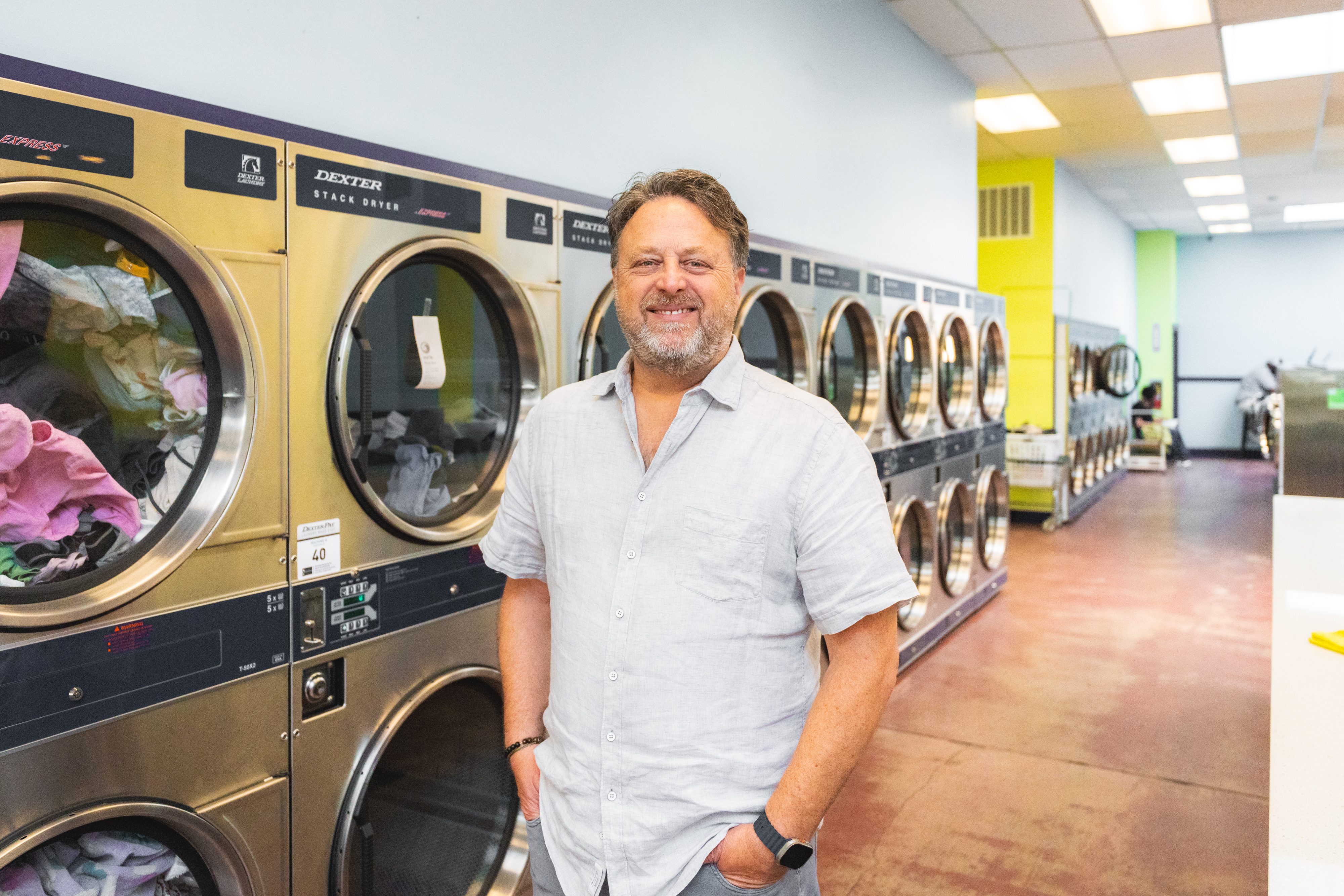 Owner Smiling Hands In Pockets By Dryers